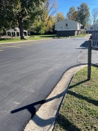 Long shot of parking lot, fence, and buildings.