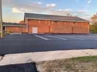 Newly repaved parking lot by some buildings.