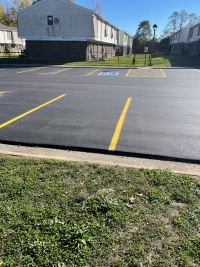 Resurfaced parking lot by apartment buildings.